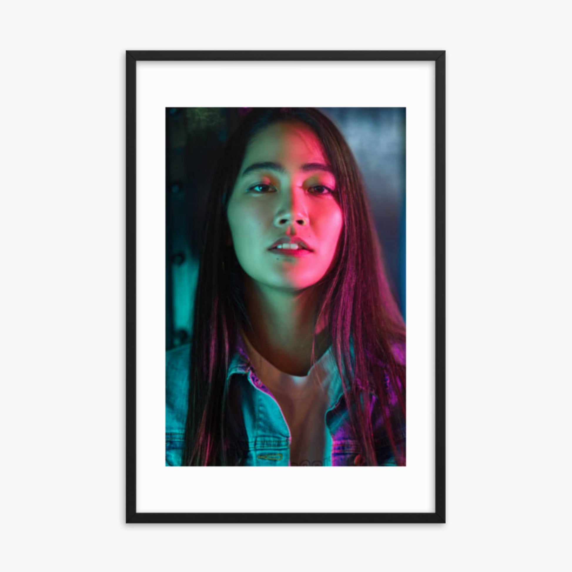 Portrait of young woman lit by colorful neon lights at night 24x36 in Poster With Black Frame